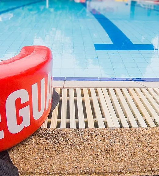 Photo of a lifeguard flotation device by the pool.