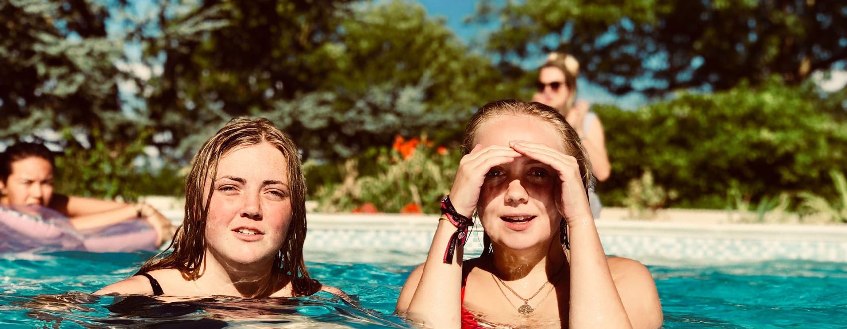 Photo of teenagers relaxing in the pool during the summer.